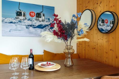 - une table avec un vase de fleurs et une bouteille de vin dans l'établissement Edelweiss 2 Apartment, à Chamonix-Mont-Blanc