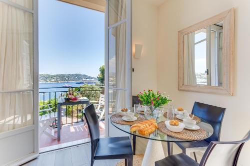 une salle à manger avec une table et des chaises et un balcon dans l'établissement BELLE DARSE AP4454 By Riviera Holiday Homes, à Villefranche-sur-Mer