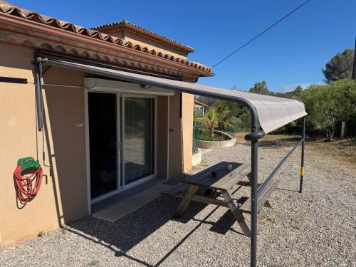 awning over a bench in front of a house at DOMAINE MAXXIM in Clermont-lʼHérault