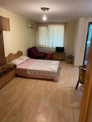 Un dormitorio con una cama y un televisor. en Апартамент генерал столетов, en Varna