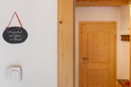 a chalkboard sign hanging on a wall next to a door at Untertalhof in Castelrotto