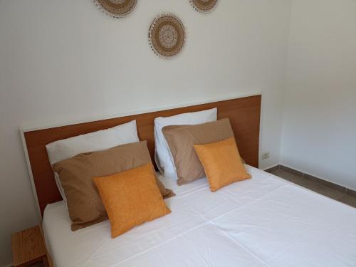 a white bed with brown pillows on top of it at Le nid cosy in Tabarka