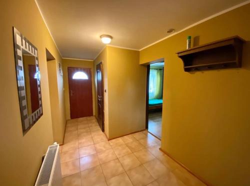 a hallway of a house with yellow walls and a door at Domek letniskowy Zagroda Starzyka in Meszna Opacka