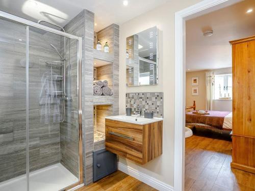 a bathroom with a shower and a sink and a toilet at Wit's End Holiday Cottage in Woodhall Spa
