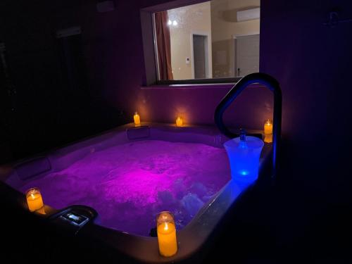a purple bath tub with candles and lights in it at Cataleya Resort & Spa in Notaresco