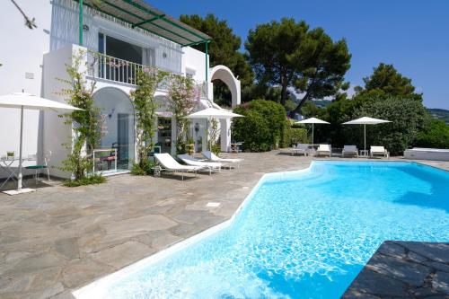 a villa with a swimming pool in front of a house at Il Carrubo Capri in Anacapri