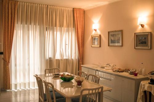 a dining room with a table and a kitchen at La Casa Di Rosa in Matera