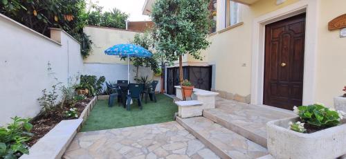 a patio with a table and chairs and an umbrella at Villa Giava in Francavilla al Mare