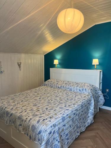 a bedroom with a large bed with a blue wall at Casa Lanza in Chioggia
