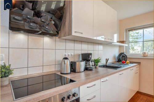 a kitchen with white cabinets and a counter top at Förster-Schrödter-Str 10-14 Strandbrise in Ostseebad Koserow
