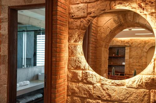 a brick wall with a mirror in a bathroom at Chateau Cabana Resort in Jbeil