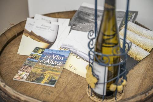 a bottle of wine sitting on a table with books at Loft de charme 4 étoiles confort haut de gamme garage privatif in Barr