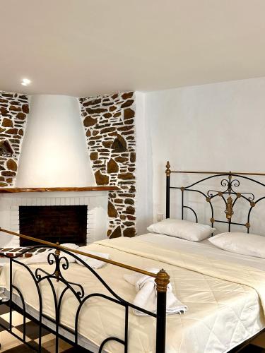 a bedroom with two beds and a fireplace at Jasmine of Cyclades in Kinion