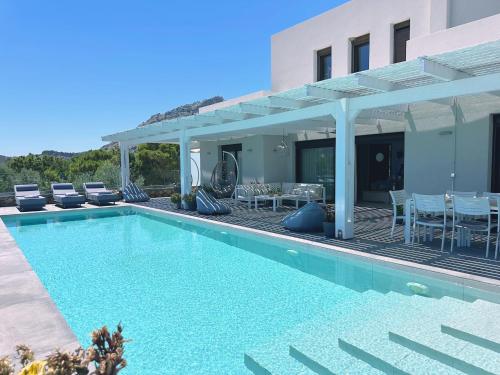 a swimming pool in front of a house at Solis Lindos Villa in Lindos