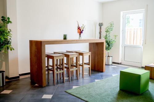 a kitchen with a bar with four stools at Hotel Donau-Ries in Mertingen