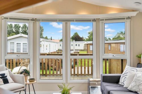 a living room with large windows and a couch at The Chester-2 bed Static Caravan in Oxnam