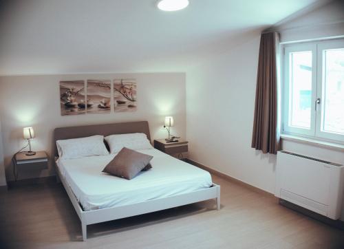 a bedroom with a white bed and two lamps at Ca' del Mar in Minturno