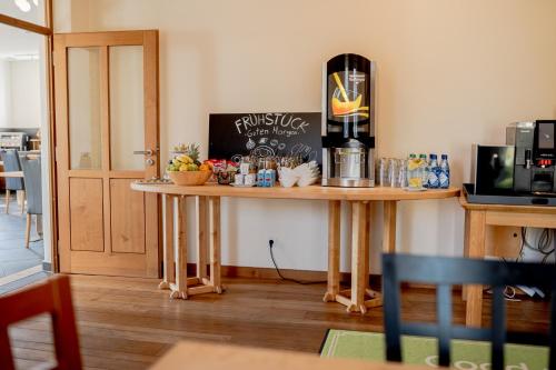 a kitchen with a table with a coffee maker on it at Hotel Donau-Ries in Mertingen