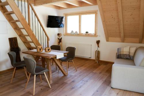 a living room with a table and chairs and a staircase at Heimatglück in Lautenbach