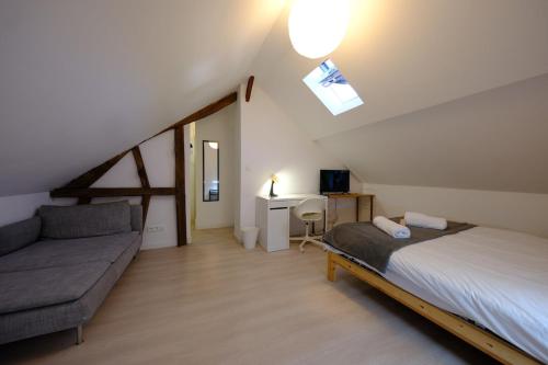 Proche Rouen - Magnifique T4 - 3 chambres في Déville-lès-Rouen: غرفة نوم بسرير واريكة منور