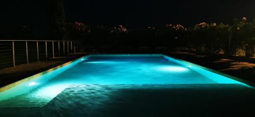 a swimming pool lit up at night at Cascina Olmetto di Sotto in Ghedi