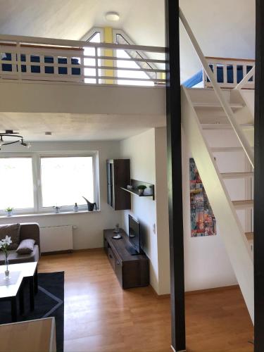 a living room with a loft with a staircase at Monteur- und Ferienwohnung BeKi in Kamp-Lintfort