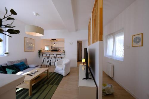 Proche Rouen - Magnifique T4 - 3 chambres في Déville-lès-Rouen: غرفة معيشة بها أريكة وطاولة