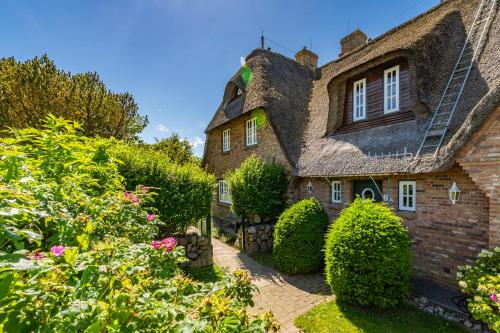 an old stone house with a thatched roof at Haus Daanshoog in Keitum