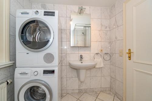 a bathroom with a washing machine and a sink at Haus Daanshoog in Keitum