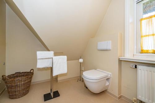 a bathroom with a white toilet in a attic at Haus Daanshoog in Keitum