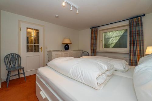 a bedroom with two beds and a window at Haus Daanshoog in Keitum