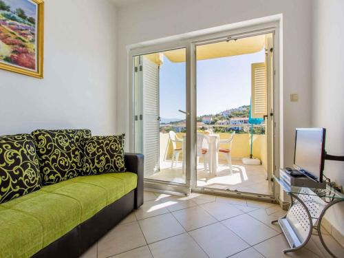 a living room with a green couch and a balcony at Apartment in Vrbnik - Insel Krk 13615 in Vrbnik