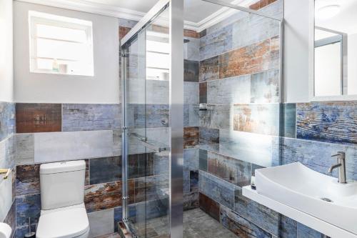 Un baño con ducha, inodoro y lavabo. en Equanimity - Stylish 4 sleeper - Wilderness Centre, en Wilderness