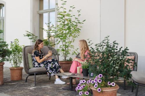two women sitting in chairs in a room with plants at B2 Hotel Zürich in Zürich