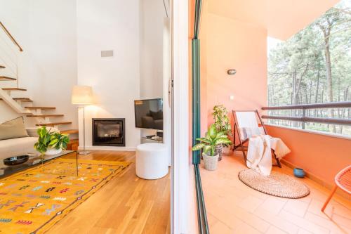 a living room with a fireplace and a tv at Apartment Aroeira Golf I in Charneca