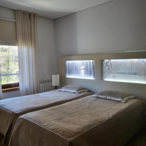 two beds in a bedroom with a window at Moinho da Ponte Velha in Bragança