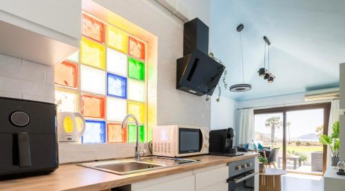 a kitchen with a sink and a colorful window at The Skippers Nest in San Miguel de Abona