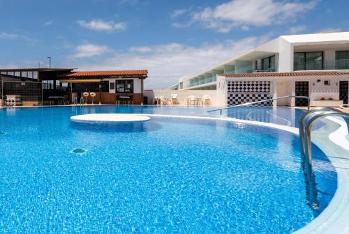 a large blue swimming pool in front of a building at The Skippers Nest in San Miguel de Abona