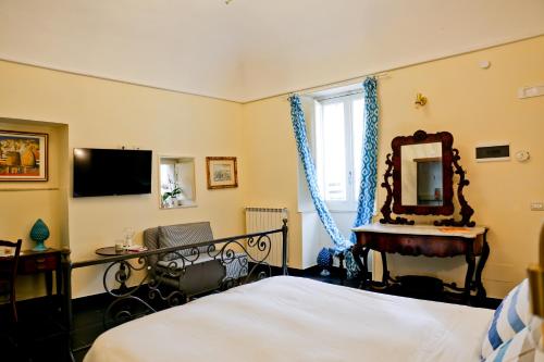 a bedroom with a bed and a mirror and a desk at Casa Catalé in Modica