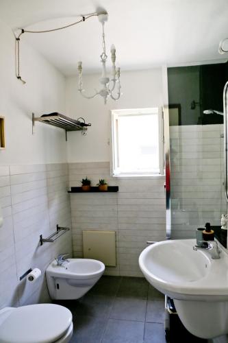 a bathroom with a sink and a tub and a toilet at Casa Catalé in Modica