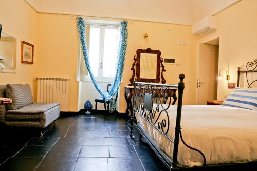 a bedroom with a bed and a mirror and a chair at Casa Catalé in Modica