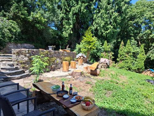 a picnic table with bottles of wine and fruit on it at Hotel Zens in Manderscheid