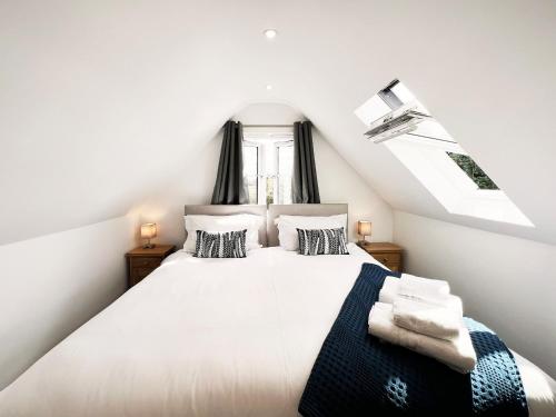 a bedroom with a white bed with black and white pillows at Blackberry Barn by The Suffolk Cottage Collection in Long Melford