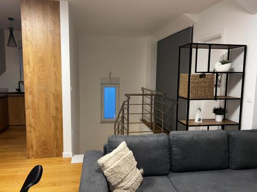a living room with a gray couch and a staircase at Apartment 98A7 in Povljana