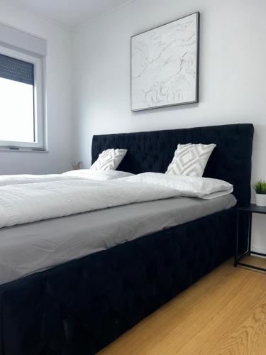 a large bed with a blue headboard in a bedroom at Apartment 98A7 in Povljana