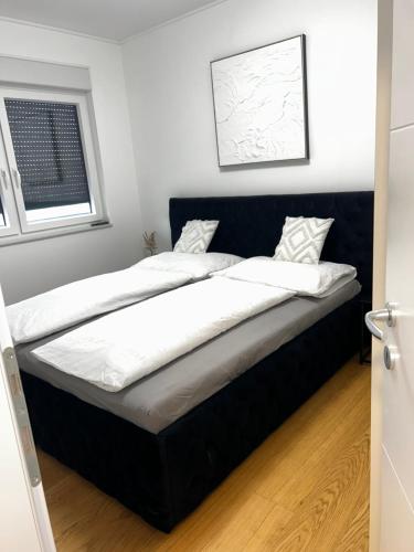 a bedroom with two beds with white sheets at Apartment 98A7 in Povljana