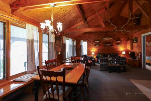 a dining room with a long wooden table and chairs at Sherbrooke Lake Cottage with Private Beach in Mahone Bay