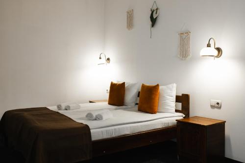 a bedroom with a bed with white sheets and orange pillows at ZimaSnow Ski & Spa Club in Bukovel