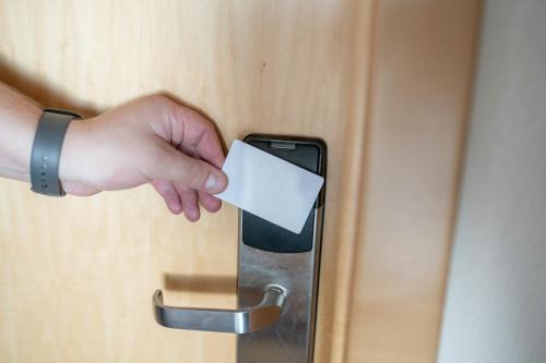 a person holding a white piece of paper in a door at Hotel Donau-Ries in Mertingen