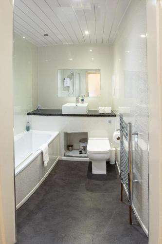 a bathroom with a tub and a toilet and a sink at 3 Bedroom Apartment with castle views in Edinburgh